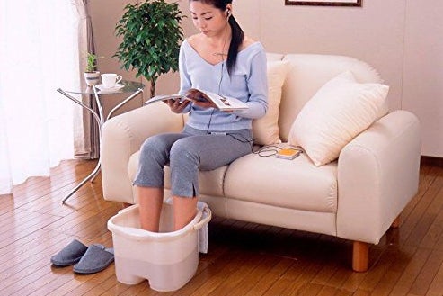 Woman with her feet inside a Inomata spa bucket.